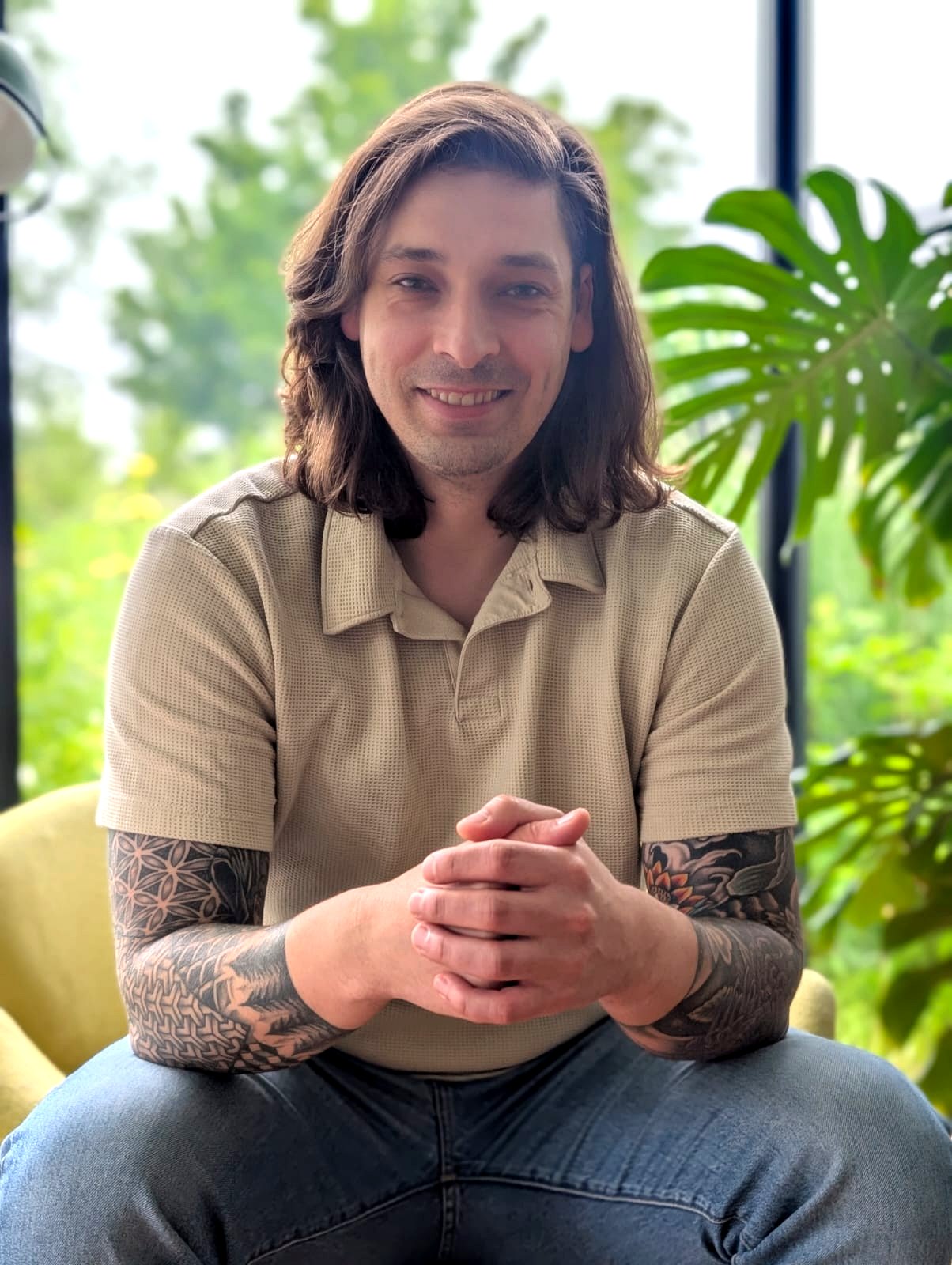 Martin, de host, lachend tussen de kamerplanten